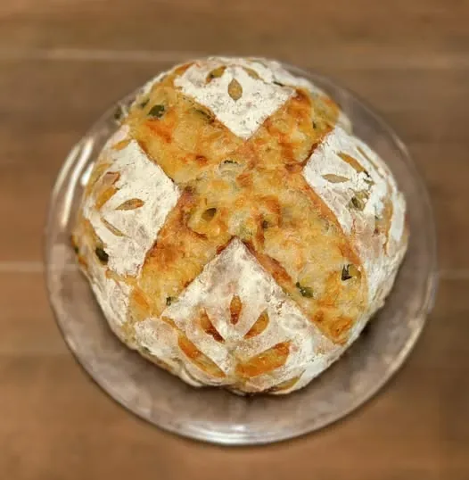 Jalapeno cheddar sourdough loaf with a golden cheese crust